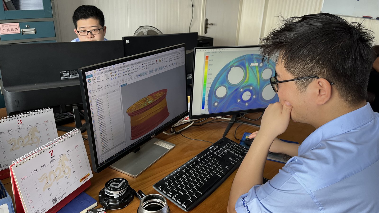 RAYONE engineers reviewing 3D wheel model and FEA analysis